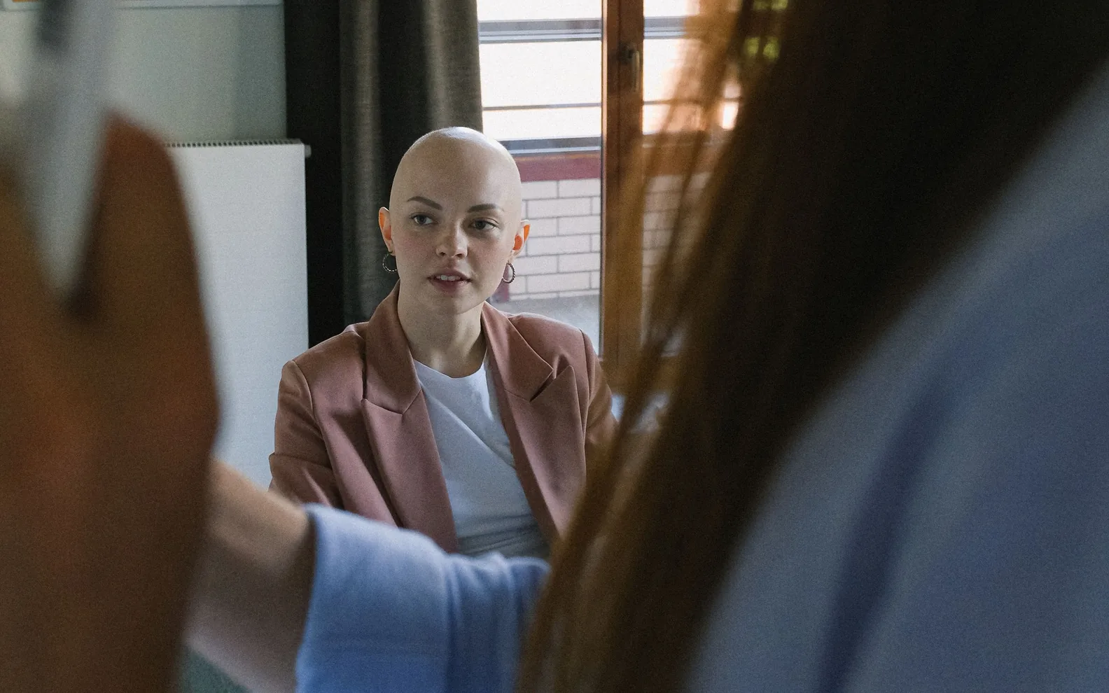 A colleague listening during a discussion beside a whiteboard.