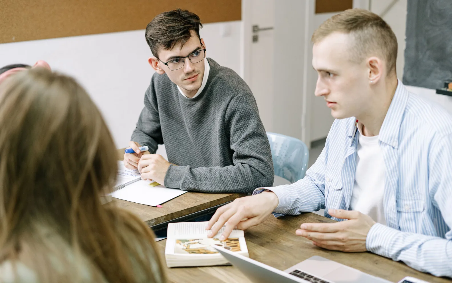 Three colleagues exchanging ideas at a work table.