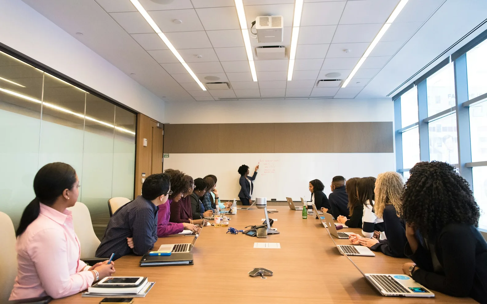 A colleague speaking while others listen around a meeting table.