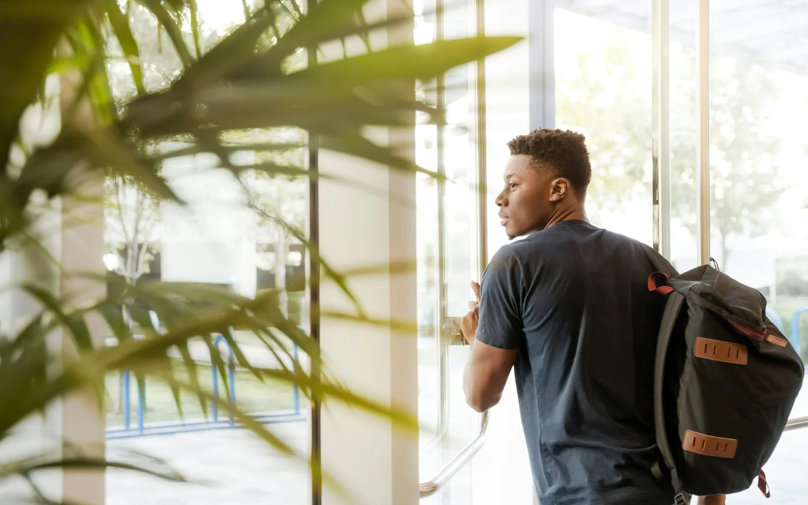 A professional arriving through a glass office door.